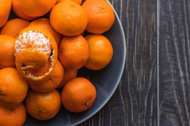 a bowl of ripe orange tangerines shot from above clipart