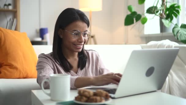 Vegyes rasszista nő szemüveges típus laptopon, és ül a földön otthon nappali Spbd. Boldog nő.