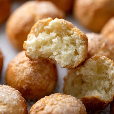 Taze pişmiş yiyecekler, üzerine şeker serpiştirilmiş tatlı çörekler. Yumuşak hamurdan yapılmış yuvarlak çörekler, ortadan ikiye bölünmüş, yakın plan. Kahvaltı ya da öğle yemeği için tatlı hamur işleri. Yemek arkaplanı. Yumuşak odak