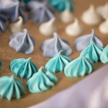 Havadar renkli kremalı pastalar, yaklaşın. Fırından yeni çıkmış kağıt üzerinde nefis tatlılar. Hassas yumurta tatlısı veya hamur işi, yemek arkaplanı. Yumuşak odak