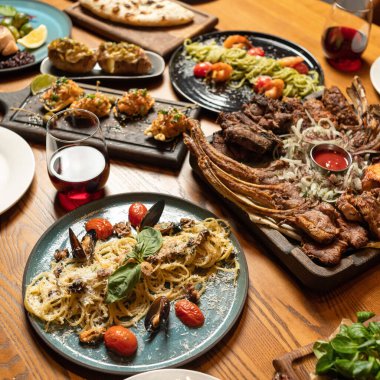 Renkli parlak yiyecekler. Kızarmış domuz kaburgası ve spagetti tabağı. Yürekli bir yemek ya da şenlikli bir ikram. Restoranda öğle yemeği. Üst Manzara. Uzayı kopyala Yumuşak odaklanma. Web pankartı için kare biçimi