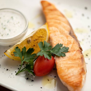 Kırmızı balık, somon ya da alabalık, sebzeyle pişirilmiş ya da kızartılmış. Domatesli, limonlu, maydanozlu ve soslu balık fileto dilimi. Yaklaş, yavaşça odaklan.