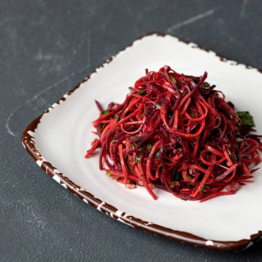 Taze kırmızı salata, pancar kökü, havuç ve kil tabakta otlar. Doğal vitamin ürünü. Sağlıklı sebzeler ve eko salata. Yiyeceğin parlak rengi. Yumuşak odaklanma, kare format. Üst görünüm