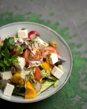 Taze sebze ve peynirli salata. Domates, turp, salatalık, zeytin, sebze ve feta vitamini karışımı. Tatil ya da bayram yemeği, güzel servis edilmiş yemek tabağı. Yumuşak odaklanma. Kapat.