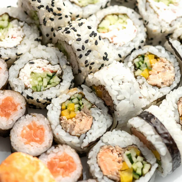 Sushi tuna rolls decorated with sesame seeds and masago or tobiko caviar. Inside-out Sushi Set. Different types of sushi rolls. Asian or Japanese food, Oriental cuisine. Close up shot. Top view