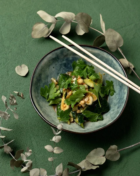 Mísa asijského vegetariánského jídla s okurkou a celerem nebo petrželkou. Jsou na ní čínské hůlky. Horní pohled. Pikantní orientální pokrm, panasijská kuchyně — Stock fotografie