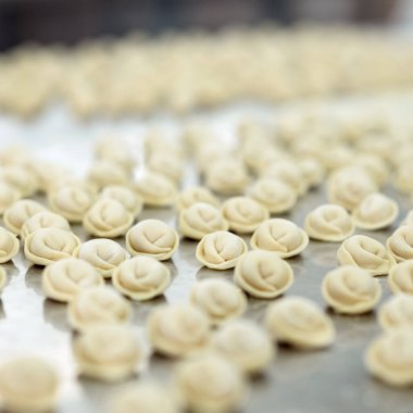Pişmemiş hamur hamuru ürünü, ravioli ya da hamur köftesi pürüzsüz yüzeye yansıyor. Yemek pişirme süreci. Yumuşak odaklanma. Geçmişi ya da dokusu. Yemek yemek veya dondurmak için uygun gıdanın hazırlanması