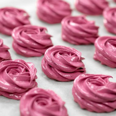 Marshmallow pişirme işlemi. Kağıt üzerinde pasta poşetinden pembe gül şekilli tatlılar, yakın çekim. Ev yapımı fırın ya da pasta. Yumuşak odak