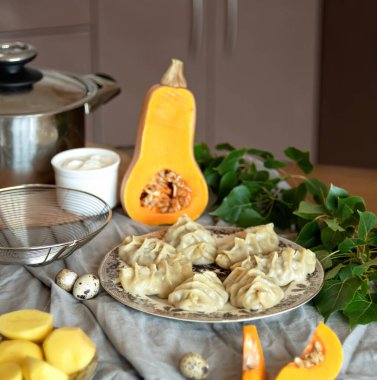 İçinde kabak ve patates bulunan kaynamış hamur köfteleri. Masa örtüsü, malzemeler ve mutfak gereçleri. Bulanık arkaplan, kopyalama alanı. Hamur dolması. Uygun Gıda. Vejetaryen gıda konsepti