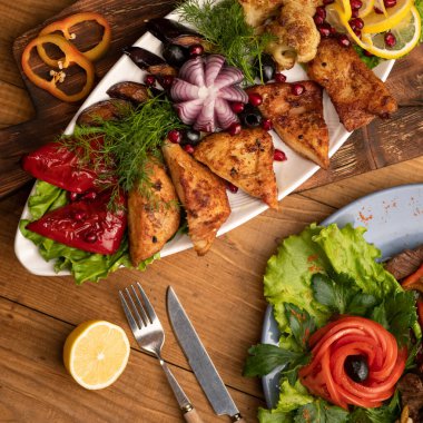 Düz yerde yemek vardı. Şenlik yemeği, atıştırmalık ya da aperatif. Ahşap masa arkasında et ve sebzelerle süslenmiş güzel tabaklar. Yumuşak odaklanma. Üst görünüm