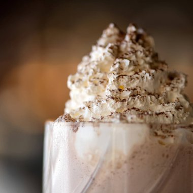Milkshake kokteyli üzerine rendelenmiş çikolata serpiştirilmiş havadar köpük. Kabarık kremalı tatlıyı ya da bulanık arka planda smoothie 'yi kapat. Yumuşak odaklanma. Soğuk içecek. Arka plan bulanık. Yumuşak odak