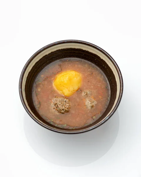 Томатний суп з фрикадельками. Миска з багатим бульйоном ізольована на білому тлі. Вертикальний формат — стокове фото