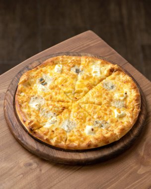 Eritilmiş parmesanlı peynirli pizza ve ahşap kesim tahtasında mozzarella. Vejetaryen ya da vejetaryen yemeği. İtalyan yemeği. Dikey format. Resmin üstüne boşluk kopyala