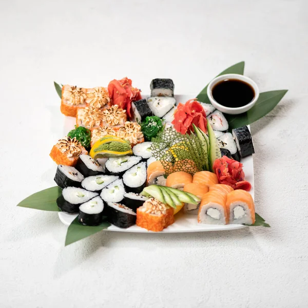 寿司セット、白い背景にロールのプレートを提供しています。伝統的な和食。健康的な東洋料理。ウェルネスの概念。撃たれたぞ。トップサイドビュー。ソフトフォーカス — ストック写真