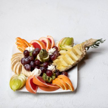 Tropikal meyve ve böğürtlenli meyve salatası, beyaz arka planda izole edilmiş yemek tabağı. Uzayı kopyala Yumuşak odak