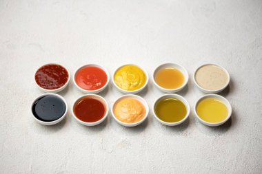 Crockery 'de büyük renkli soslar. Farklı soslar, mayonez, hardal, soya sosu, yağ ve ketçap. Üst taraf manzarası. Lezzetli yemekler. Mutfak aletleri
