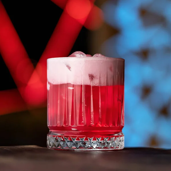 Алкогольний напій. Iced Glass з червоним коктейлем на розмитому неоновому тлі. Сторона зору. Копіювальний простір — стокове фото