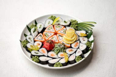 Suşi takımlı servis tabağı, beyaz arka planda yuvarlanıyor. Japon restoranı yemeği. Sağlıklı doğulu yemeği. Sağlık konsepti. Yatay biçim