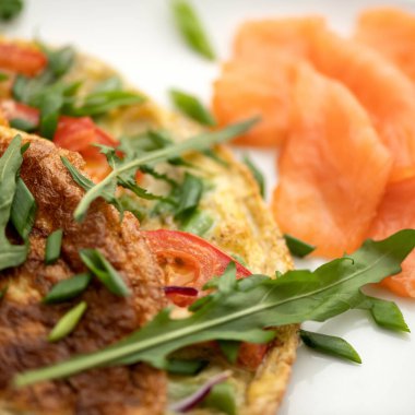 Arkaplanda roka ve kırmızı balıklı omlet. Yakın plan çekim. Sabah havası, kahvaltı. Yumuşak odak