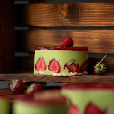 Ahşap arka planda taze çilekli jöle ya da kremalı tatlı pastası. Yan görüş. Yumuşak odaklanma. Boşluğu kopyala