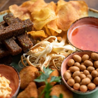 Bira çerezi. Fındık, kızarmış ekmek, patates cipsi ve füme peynir. Besleyici atıştırmalık ya da aperatif. Yakın plan çekim. Yumuşak odak