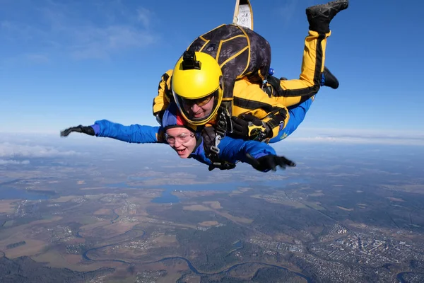 Skydiving. Tandem jump. A girl and her instructor are having fun in the sky.