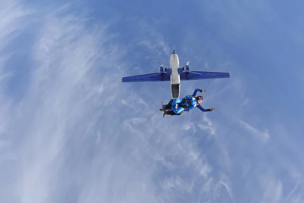 Skydiving. Tandem jump. A young woman and her instructor are in the sky.