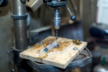 Bir işçi sondaj makinesinin bir parçasını deliyor.