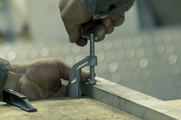 The worker fixes the part to the base with a clamp