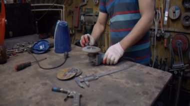 Usta, metal bir parçayı öğütücüyle delik deşik eder. 