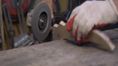 Bir çilingir öğütücü kullanarak tahta bir parçayı işliyor.