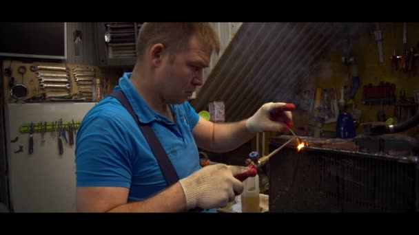 Cuivre dans un chemisier bleu soude un radiateur — Video