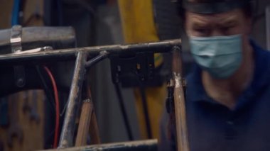 Kaynakçı tıbbi bir maske takıyor. Koronavirüs enfeksiyonu ihtimaline karşı kendini izole etme kurallarını uyguluyor. 