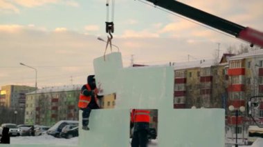 Buz panellerinin kurulumuna turuncu yansıtıcı yelek ve miğfer takanlar