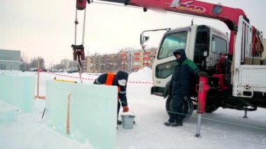 Buz panellerinin kurulumuna turuncu yansıtıcı yelek ve miğfer takanlar