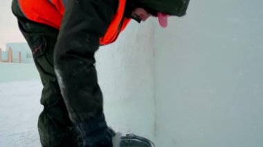 Buz kasabasının inşaat alanındaki yükleyici, buz panellerinin eklemlerini ıslak karla kaplıyor.