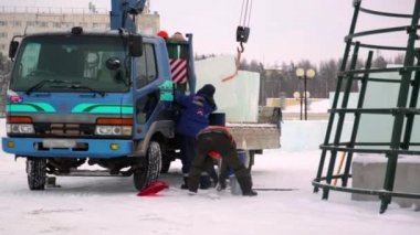 Birleştiriciler vinç kullanarak bir arabadan buz panelleri indirir.
