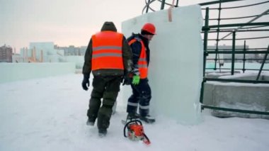 Buz kasabasının toplanma yerinde elinde kova olan bir işçi.