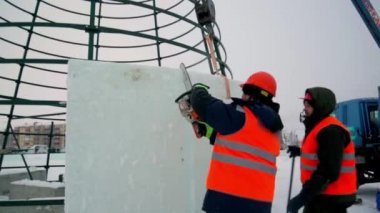 Turuncu yansıtıcı yelek giyen işçi yükleyici buz kalıbını ayarladı