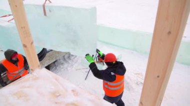 Buz panellerinin kurulumuna turuncu yansıtıcı yelek ve miğfer takanlar