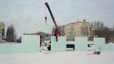 İşçi buz panelinden metal bir fırçayla karı kaldırıyor