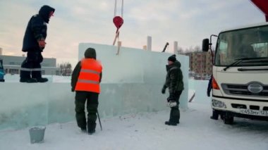 İşçiler Noel tatili için buz bloklarından bir buz kasabası inşa ediyorlar.