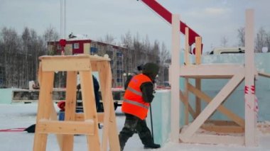 İşçi derleyici levyesi buz bloğunu hareket ettirir