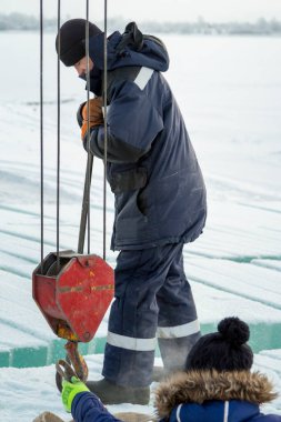 İşçiler buz kasabası inşa etmek için büyük buz tabakaları hazırlıyorlar.