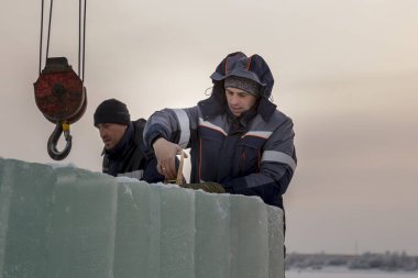 Kurucular buz panellerini vinç kullanarak arabaya yüklerler.