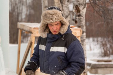 İş yerinde açık kürklü ve mavi ceketli bir adamın portresi.