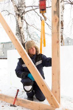 Ahşap bir kaydırağın çerçevesini monte eden işçiler