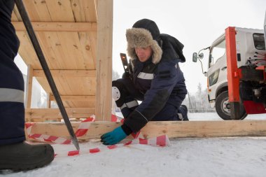 Ahşap bir kaydırağın çerçevesini monte eden işçiler