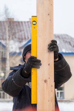 İşçi ahşap bar seviyesini ayarlar.