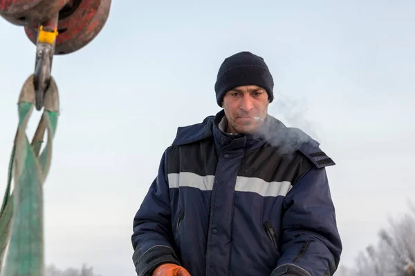 Portret Pracownika Niebieskiej Kurtce Czapce Dzianiny Haku Żurawia Samochodowego Cygarem — Zdjęcie stockowe